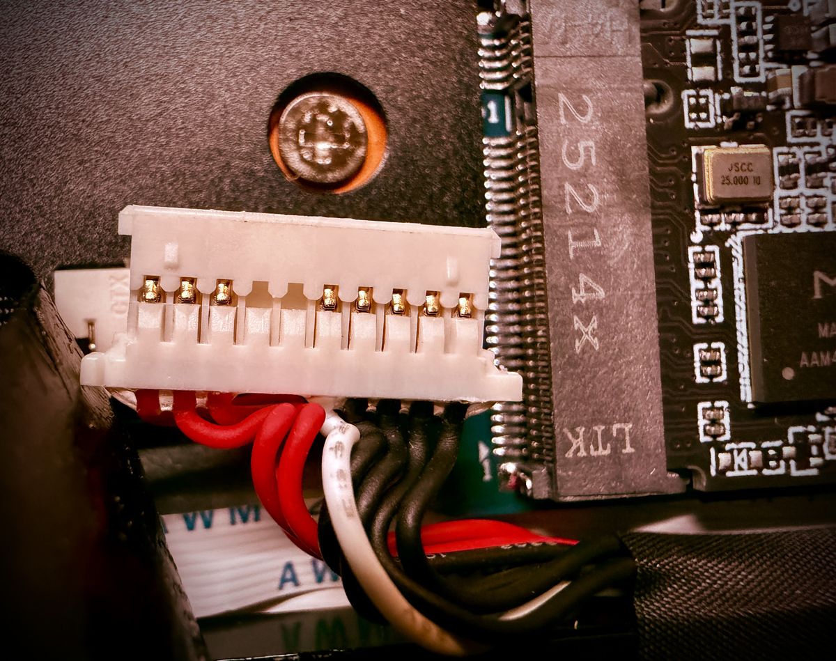 heavily edited picture of a power plug over an opened up laptop motherboard