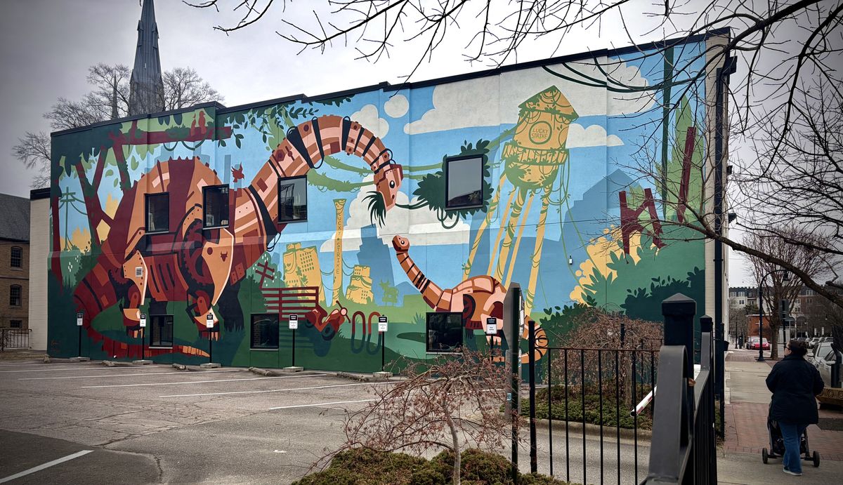 A mural with metal dinosaurs with iconic Durham landmarks