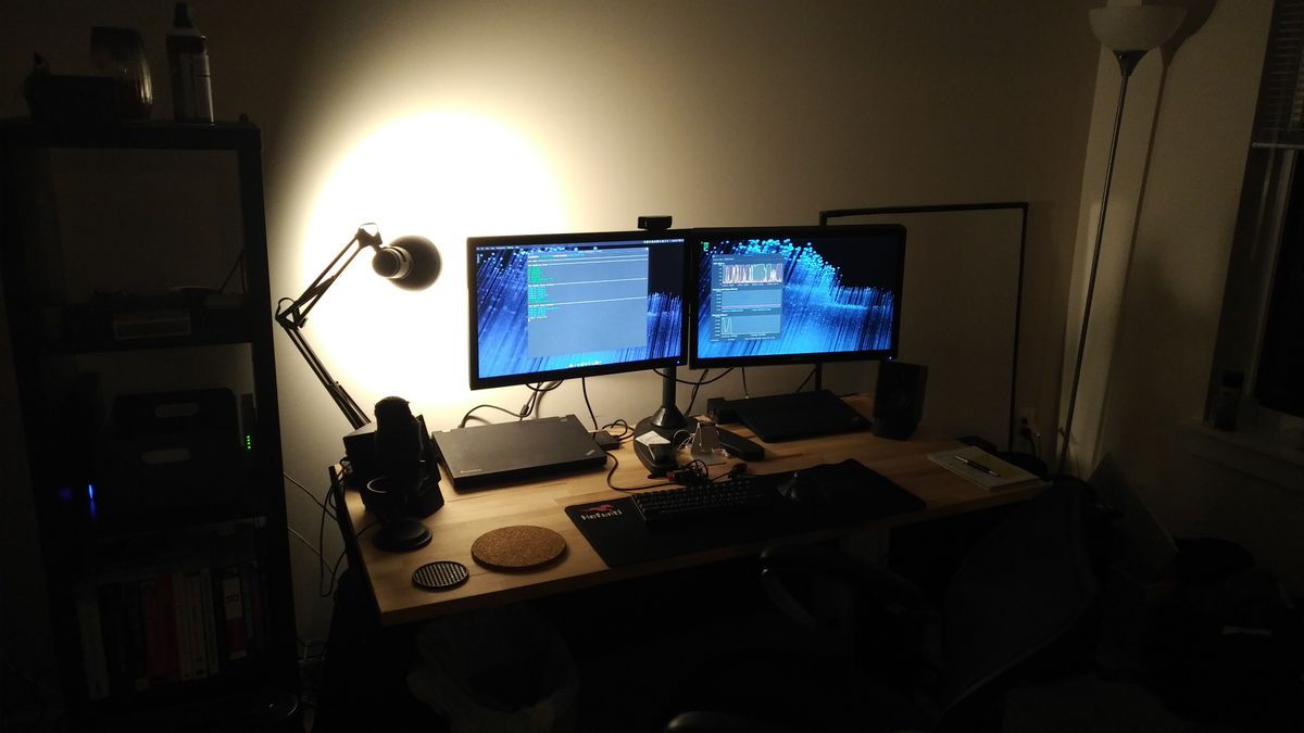 Another desk picture with two monitors and laptop docks, but from further back