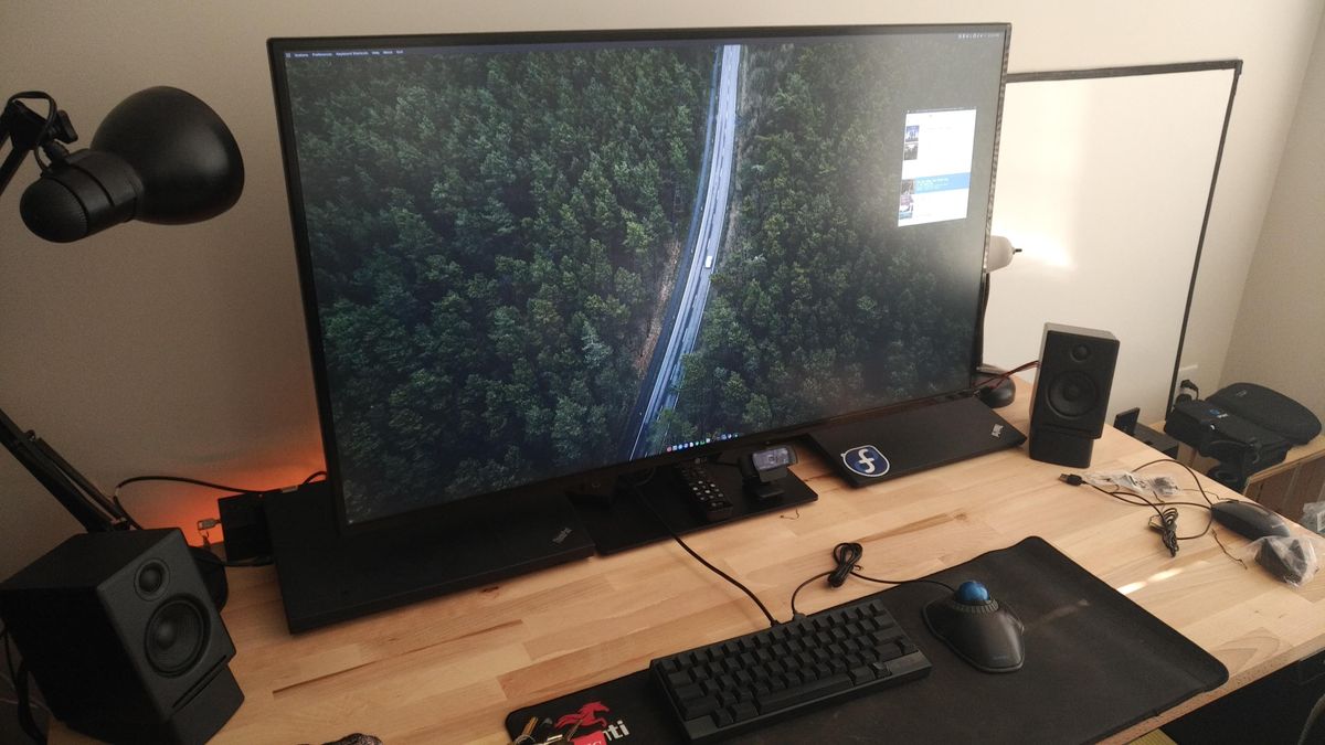 A desk with a giant monitor on it