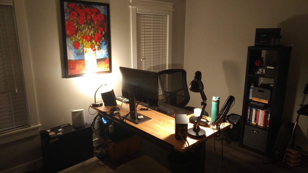 A plain room, with a wooden desk and computer on it. Facing the back of the desk in the room
