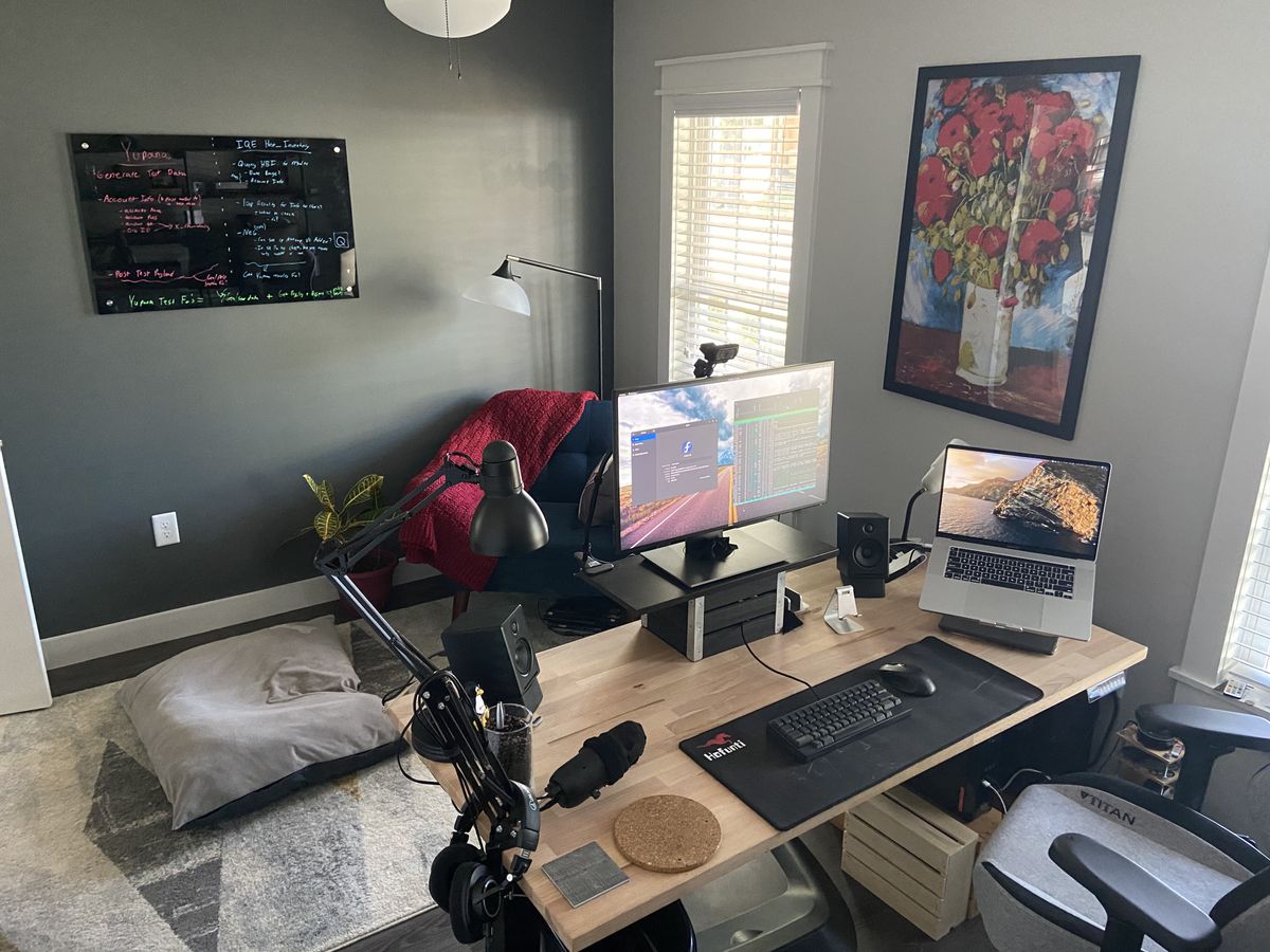 A small home office, with a wooden desk setup and computer in the middle