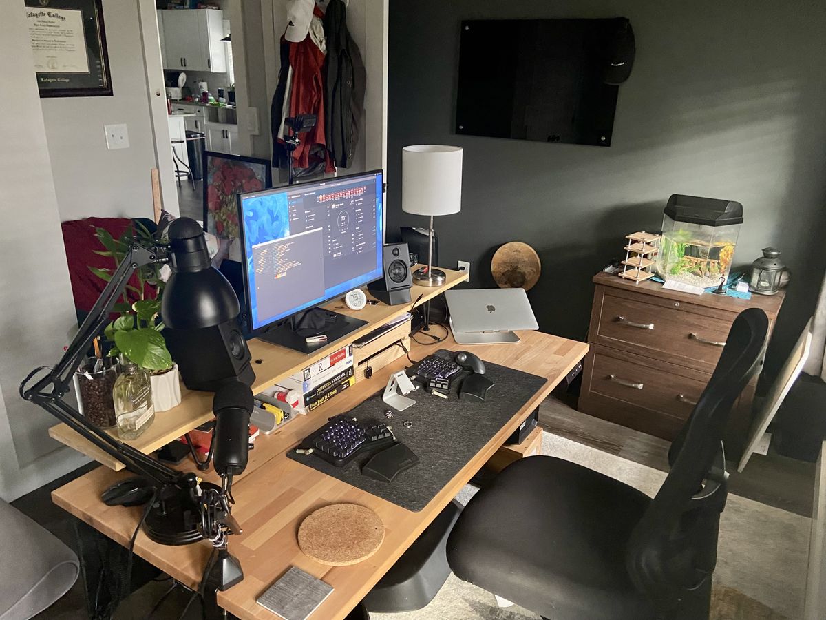 A home office with a wooden desk in the middle of it